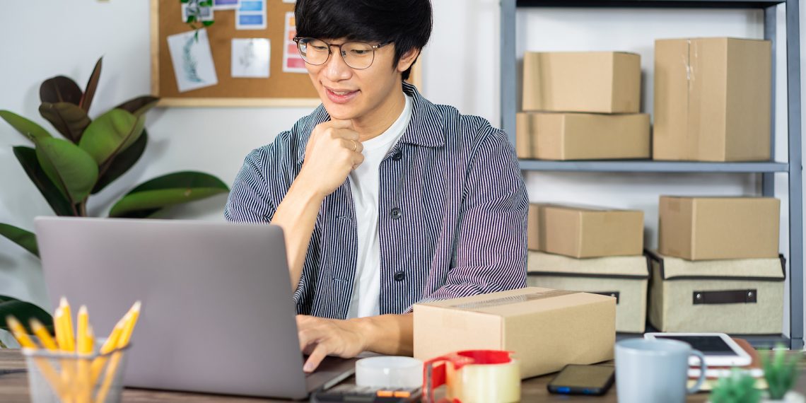 Asian business man startup SME entrepreneur or freelance working in a cardboard box prepares delivery box for customer, Online selling, e-commerce, packaging and shipping concept