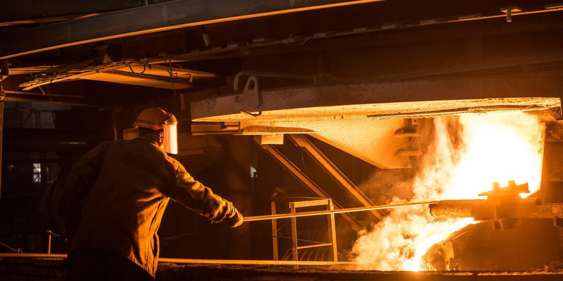 Steelworker when pouring liquid metal from arc furnace